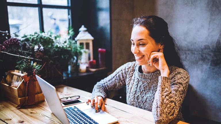 一个女人在她的小商店工作在她的笔记本电脑